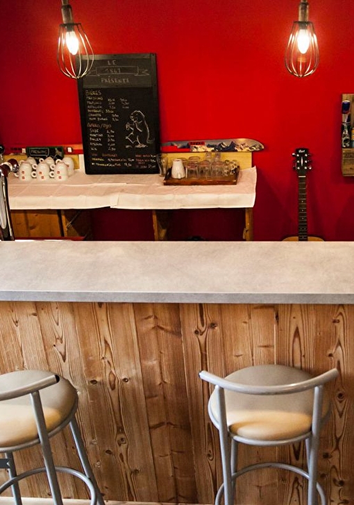 Table de bar intérieur et ses fauteuils hauts où l'on peut commander boissons et encas gourmands