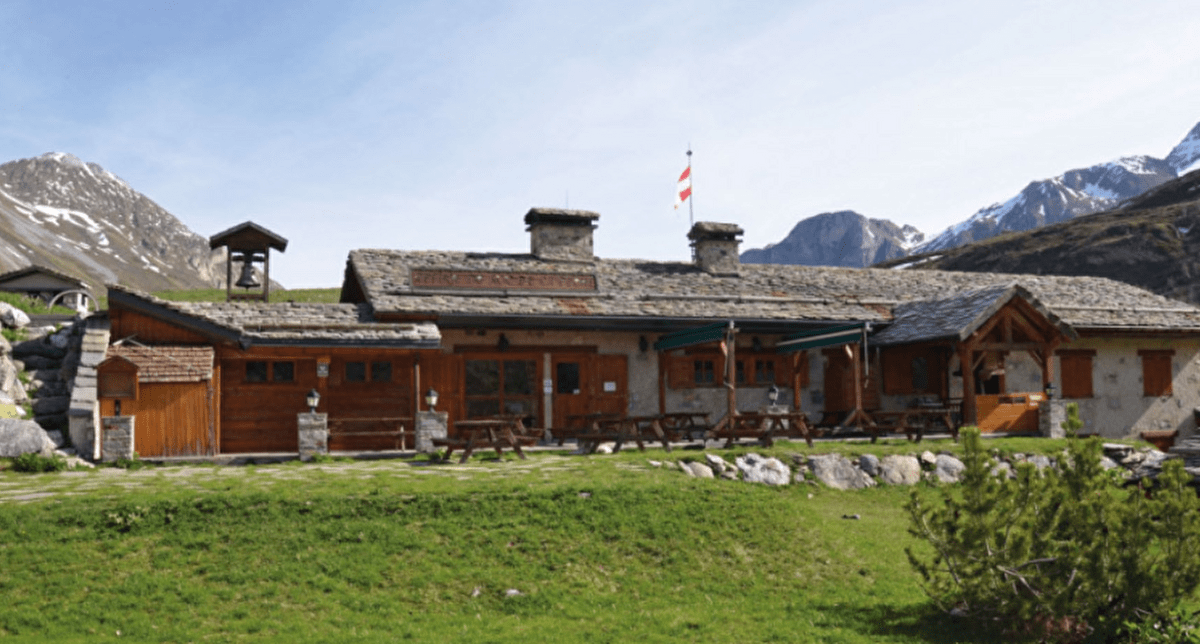 Refuge de montagne en été avec vue sur les sommets en arrière-plan
