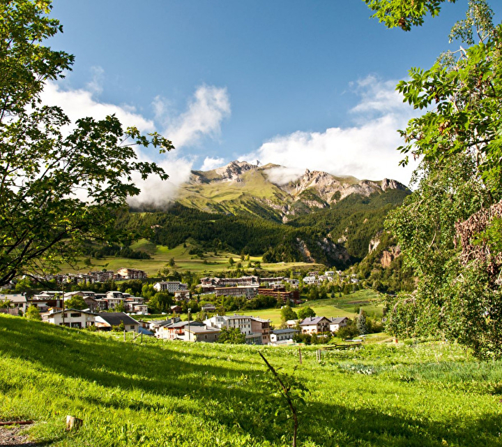 Vue sur le village entouré de nature, d'arbres et de montagnes