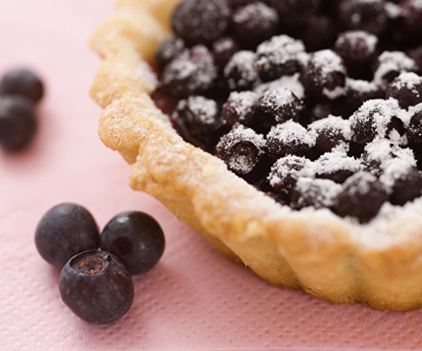 Tarte aux myrtilles soupoudrée de sucre glace sur une table