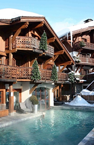 Vue sur les chalets en bois et la piscine extérieure de l'hôtel
