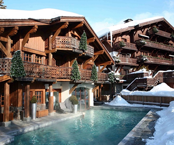Vue sur les chalets en bois et la piscine extérieure de l'hôtel