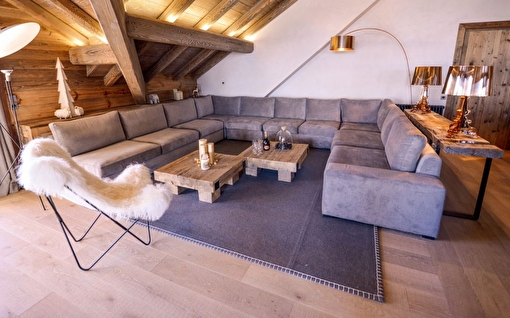 Salon et intérieur d'un chalet de montagne décoré avec canapé d'angle et fauteuils