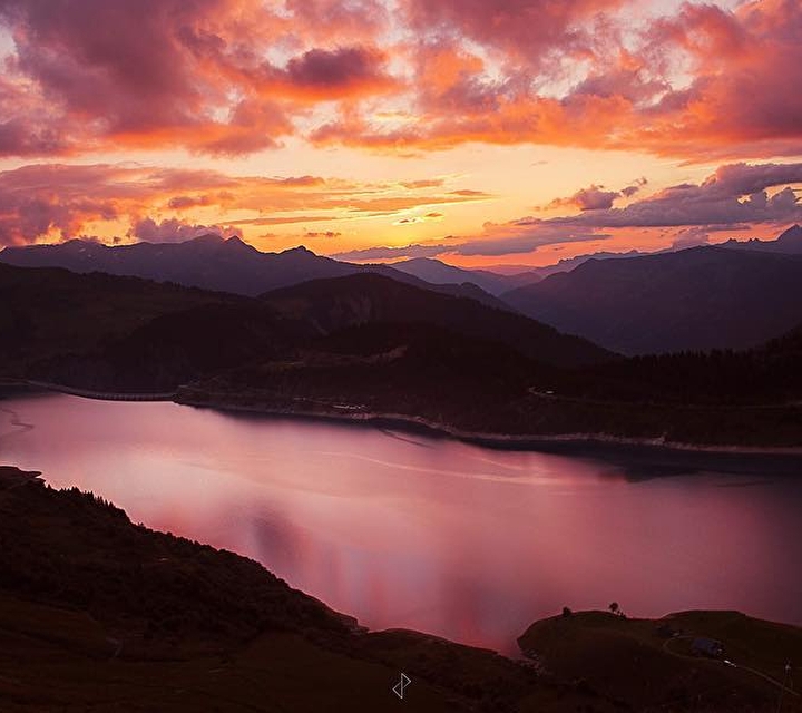 Coucher de soleil sur un lac entouré de montagnes