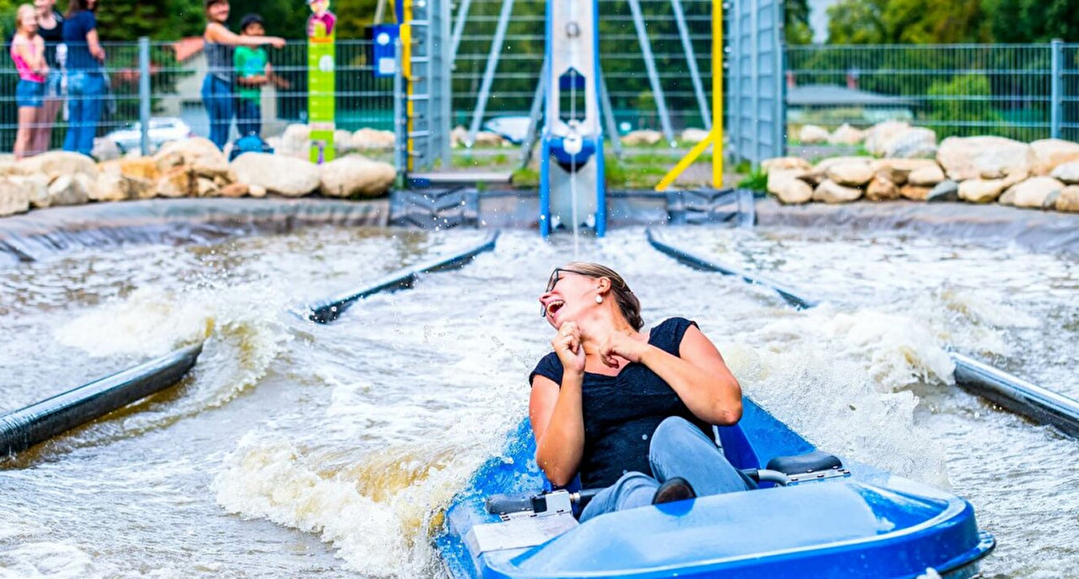 Femme glissant sur une bouée gonflable dans un parc aquatique