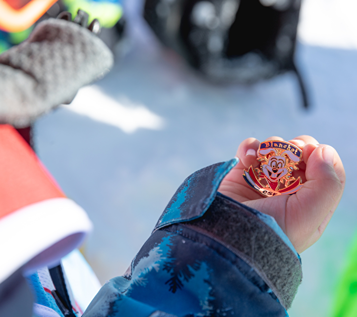 Enfant tenant dans le creux de sa main une médaille esf
