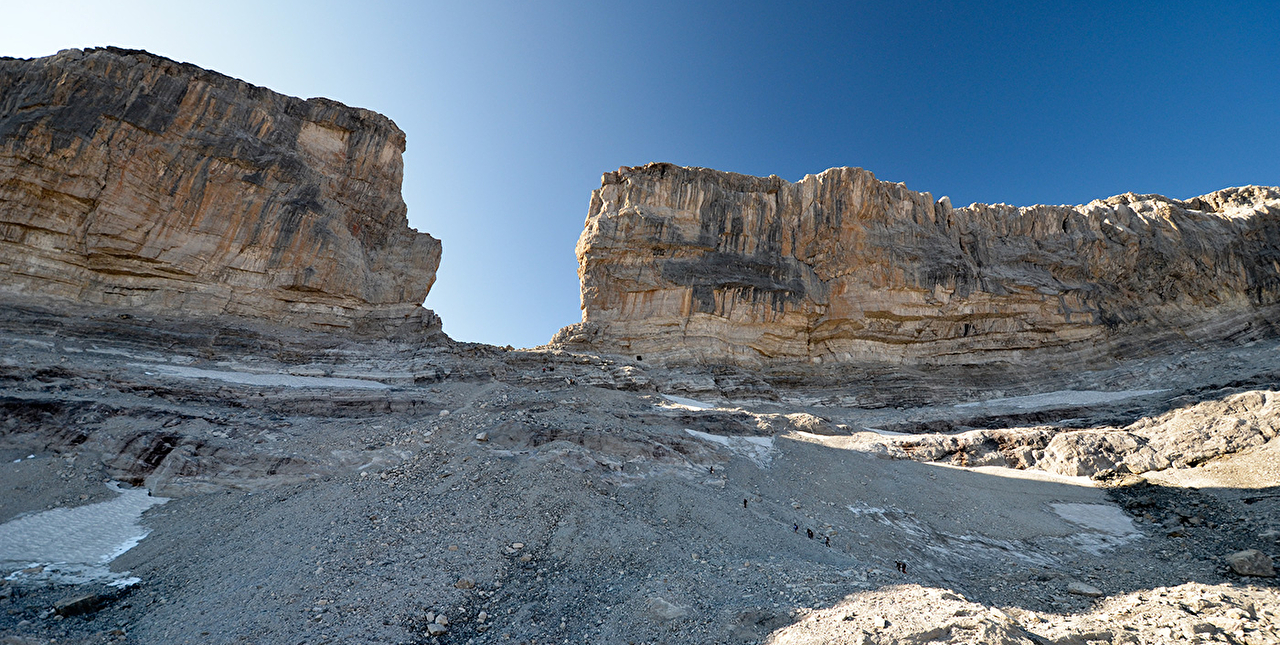 Brèche rocheuse au milieu d'une paroi montagneuse sous un ciel limpide