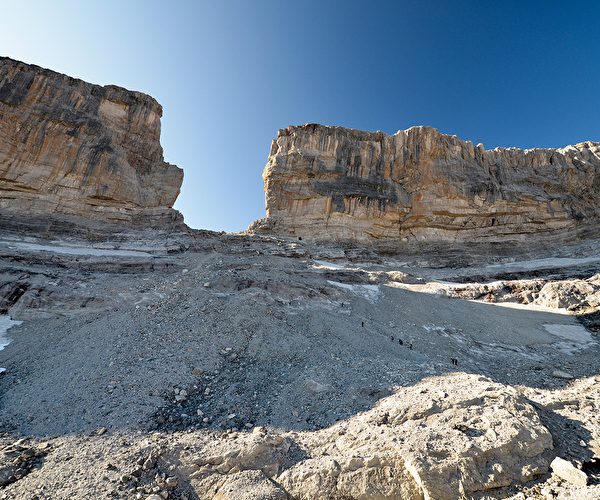 Brèche rocheuse au milieu d'une paroi montagneuse sous un ciel limpide