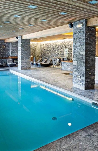 Vue sur la piscine intérieure d'un spa et son espace détente