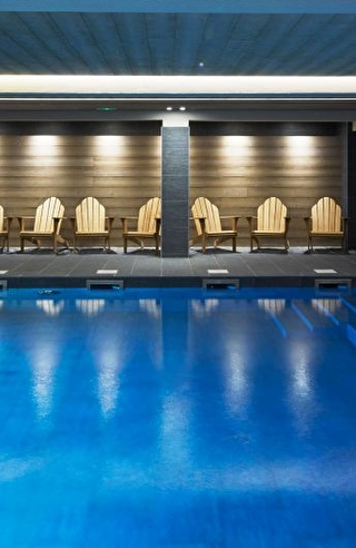 Vue sur la piscine intérieure d'un spa et sur son espace détente