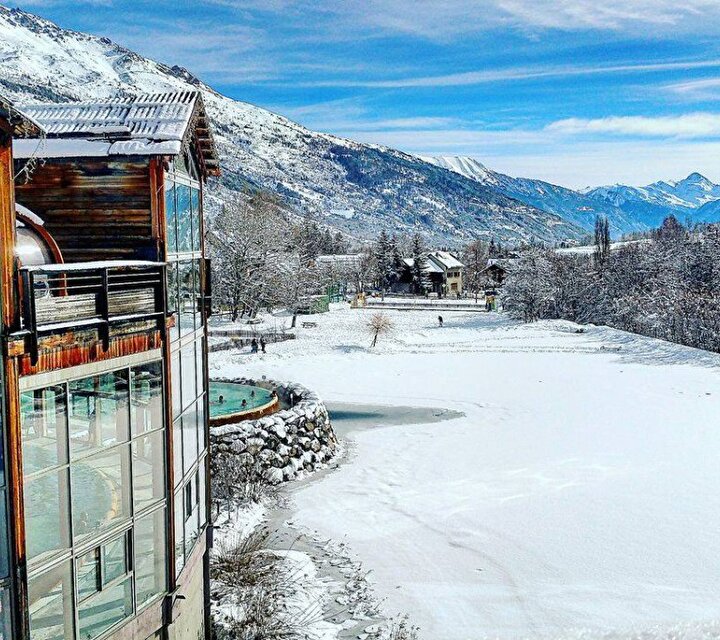 Vue sur le spa Les Grands Bains du Monêtier en extérieur face à la montagne