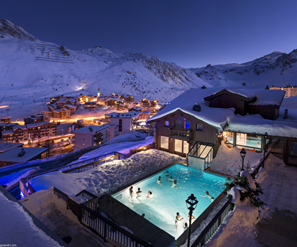 Complexe hôtelier de nuit avec lumières et piscine chauffée extérieure