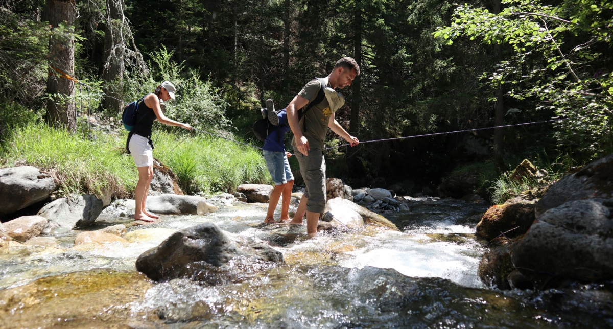Famille en train de pêcher dans une rivière de montagne en été