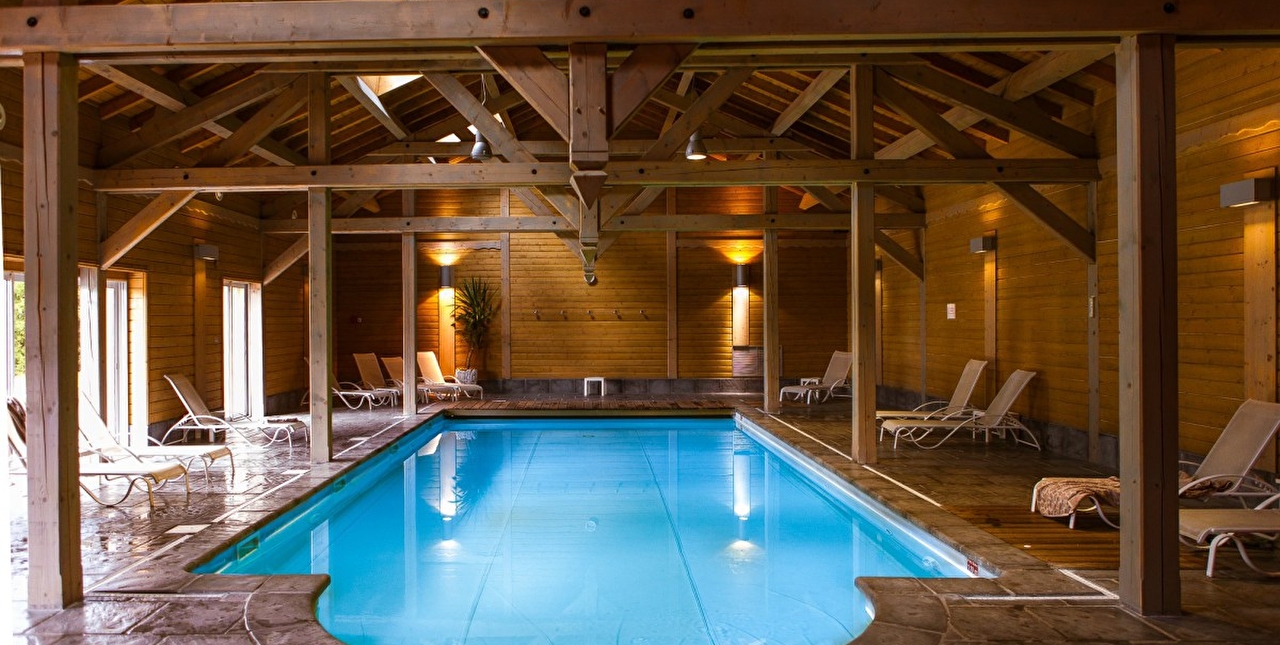 Vue sur la piscine intérieure d'un spa et sur son espace détente avec plusieurs transats