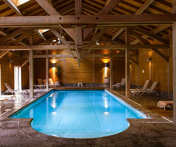 Vue sur la piscine intérieure d'un spa et sur son espace détente avec plusieurs transats