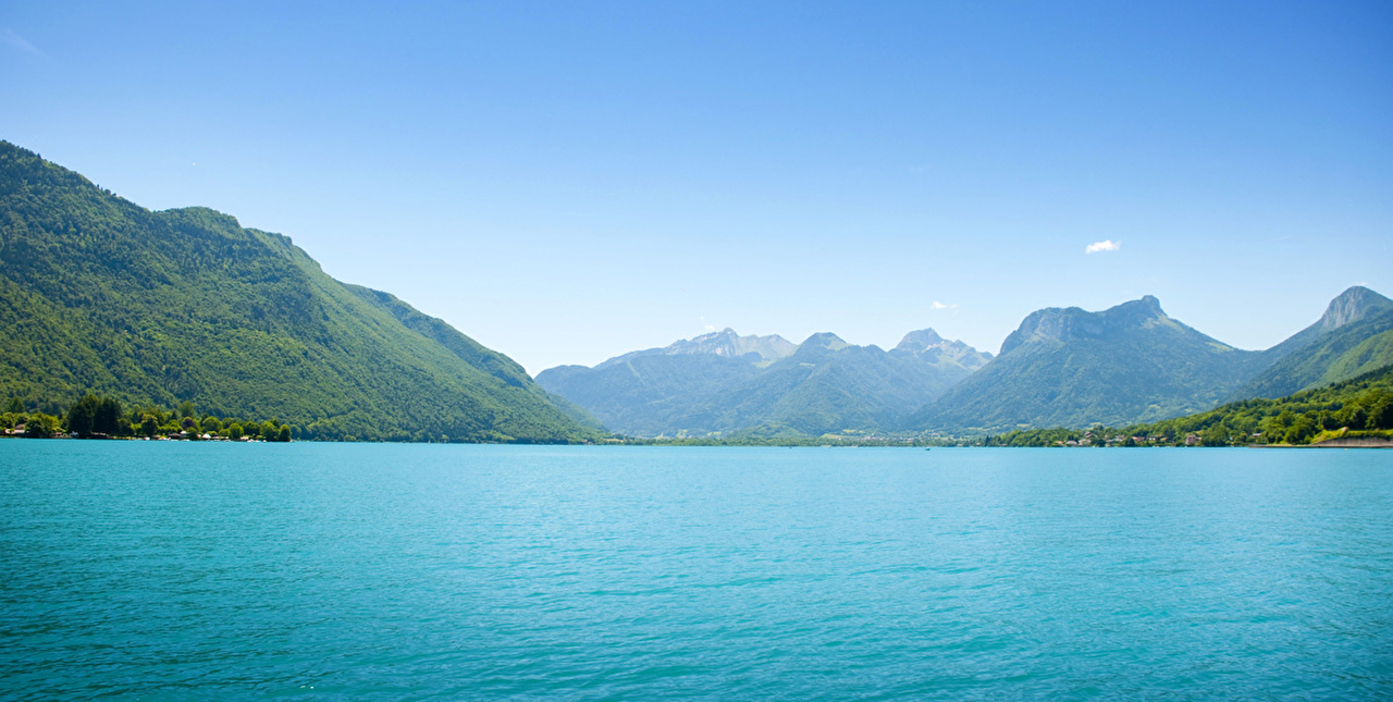 Vue sur un lac aux eaux turquoises entouré de montagnes en été