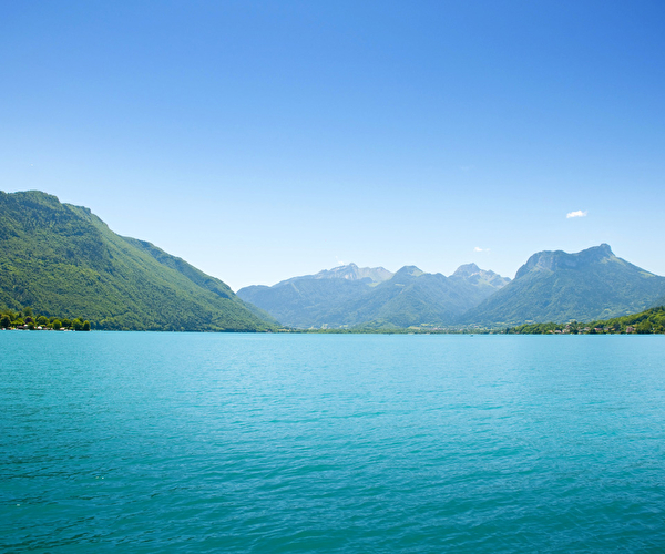Vue sur un lac aux eaux turquoises entouré de montagnes en été