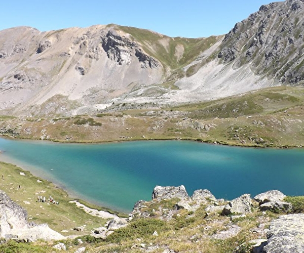 Lac aux nuances turquoises au milieu des montagnes sous un ciel bleu