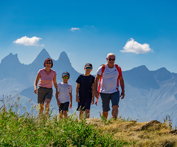 Grands-parents et petit enfants en randonnée avec vue sur les sommets