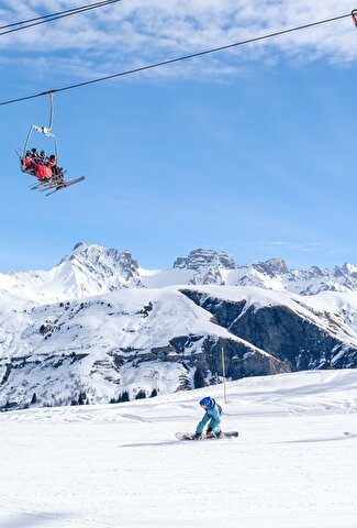 Piste de skis avec 2 skieurs et deux télésièges qui passent au dessus