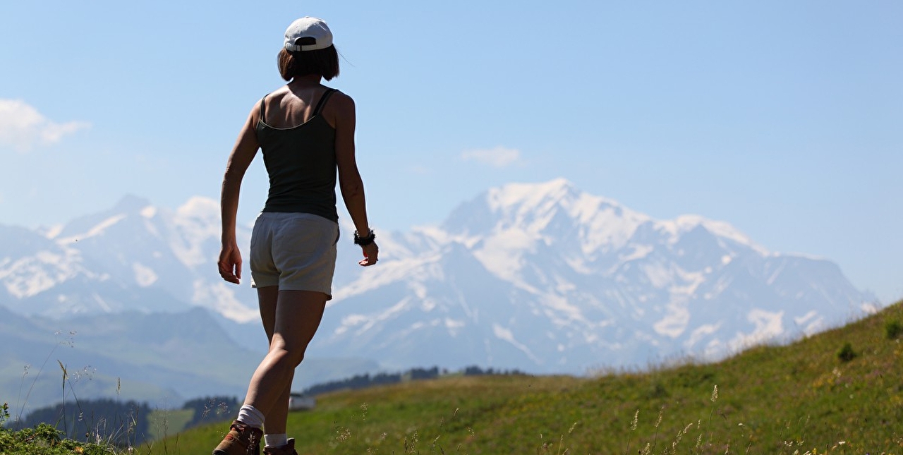 Femme au sommet de la montagne découvrant un panorama époustouflant