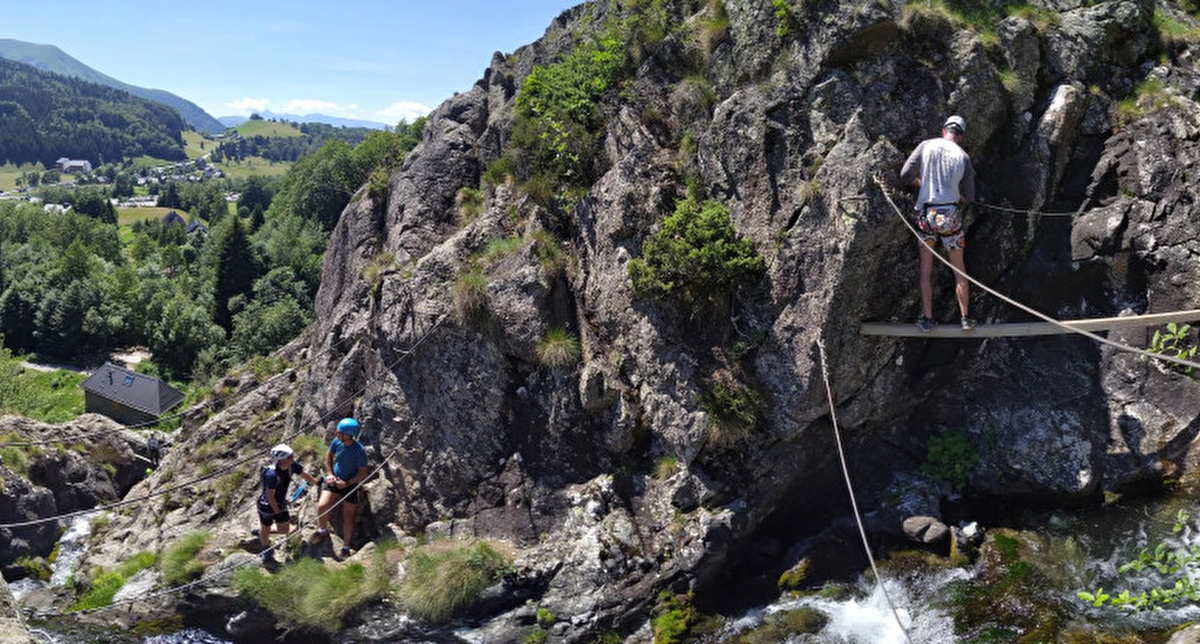 Homme et femme sur une via ferrata à flanc de montagne en été