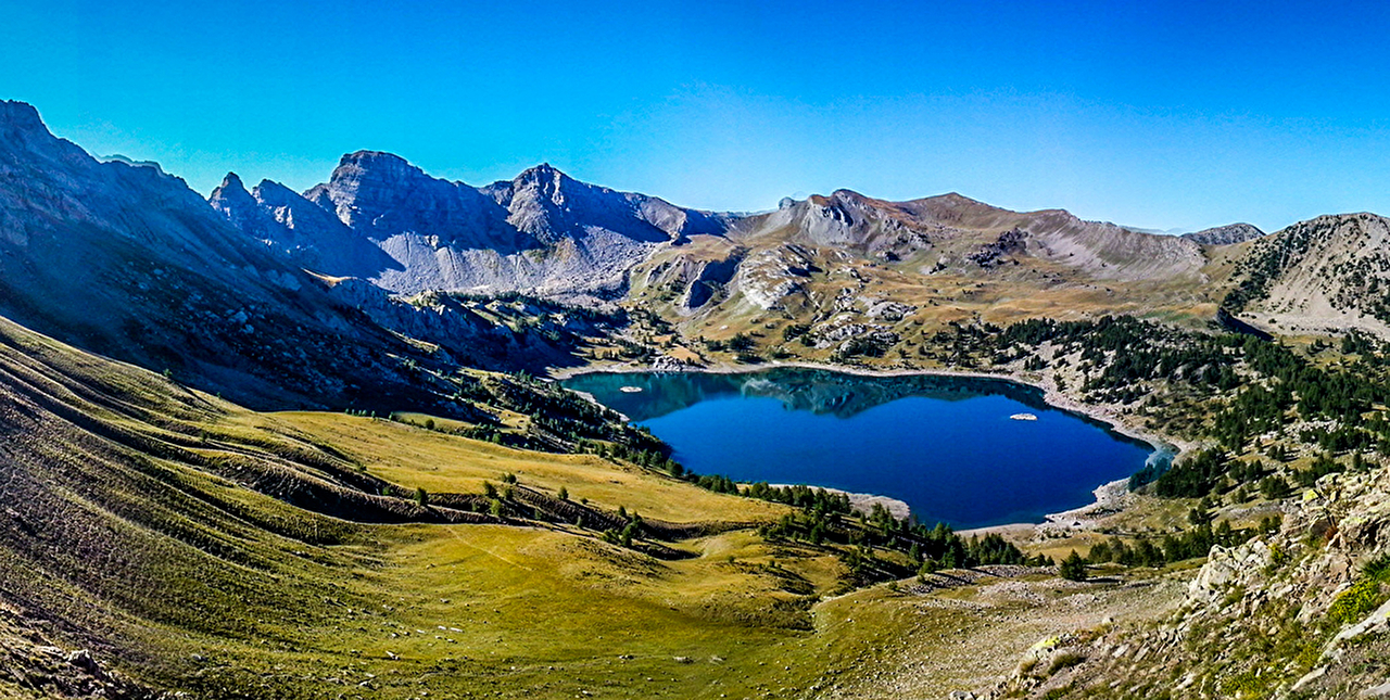 Vue sur les montagnes et un lac en pleine nature sous un ciel bleu