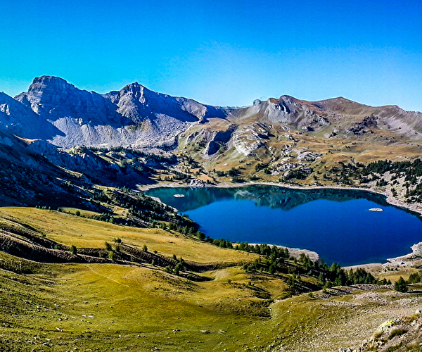 Vue sur les montagnes et un lac en pleine nature sous un ciel bleu
