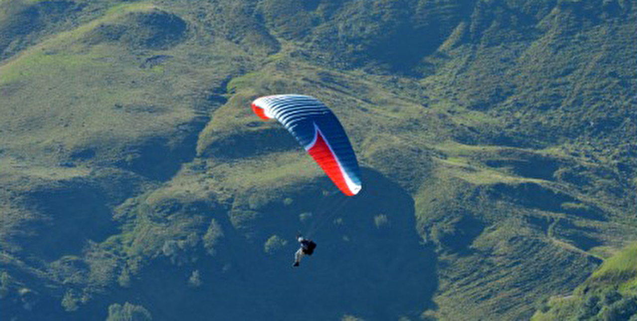 Personne effectuant un vol en parapente en montagne et en pleine nature