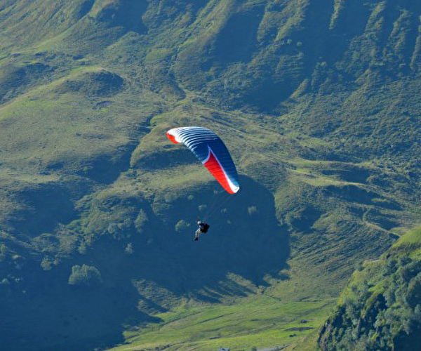 Personne effectuant un vol en parapente en montagne et en pleine nature