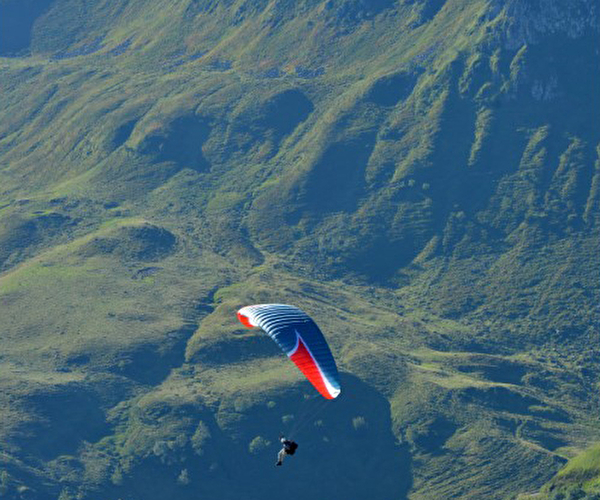 Personne effectuant un vol en parapente en montagne et en pleine nature