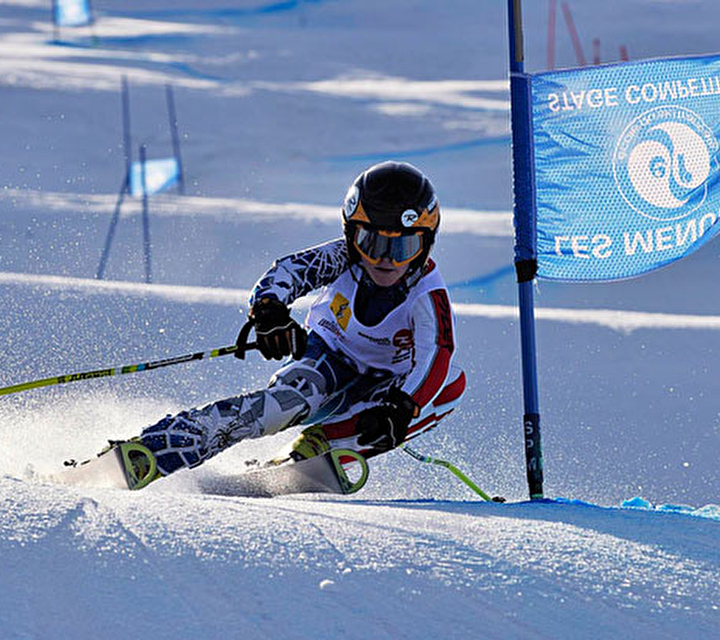 Enfant en train de faire un slalom chronométré sur une piste de ski avec portiques