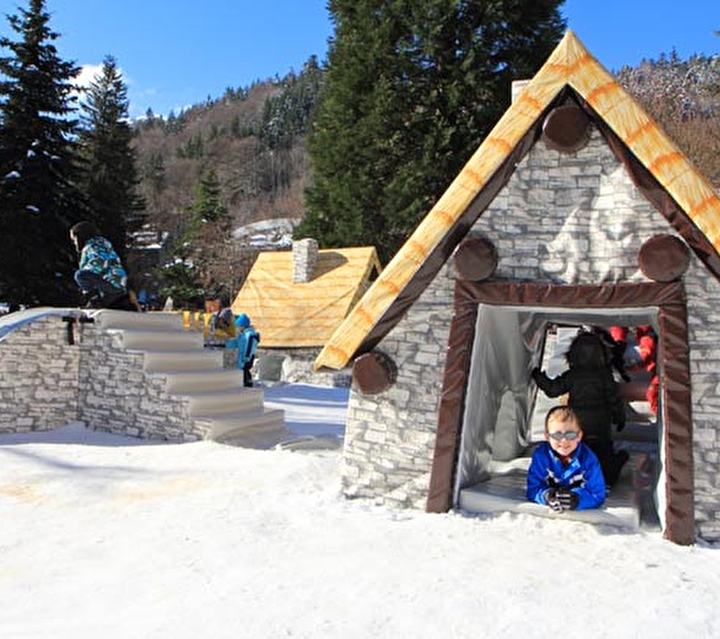 Enfants sur une aide de jeu enneigée avec structures gonflables