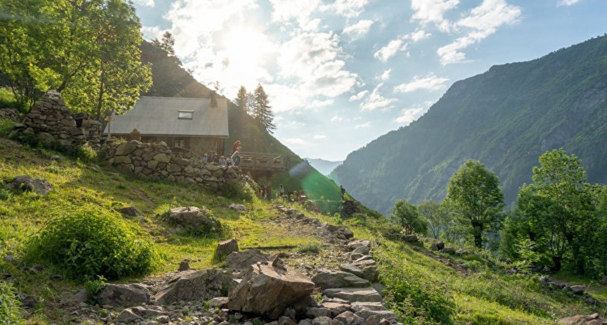 Refuge avec enfants jouant dans l'herbe, à la montagne l'été