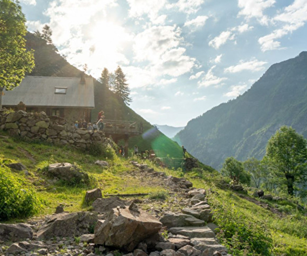 Refuge avec enfants jouant dans l'herbe, à la montagne l'été