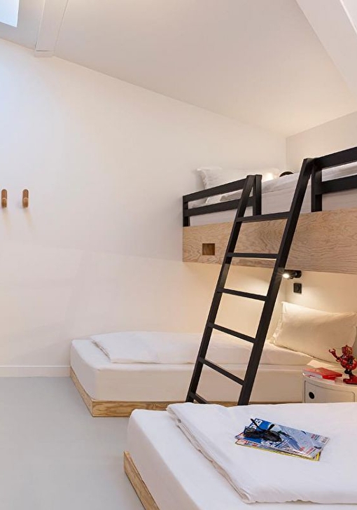 Intérieur d'une chambre multiple avec des lits et des étagères pour ranger ses affaires personnelles