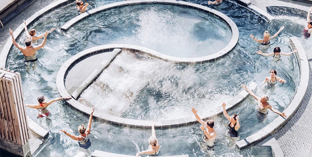 Personnes dans une piscine extérieure ronde effectuant des mouvements dans l'eau