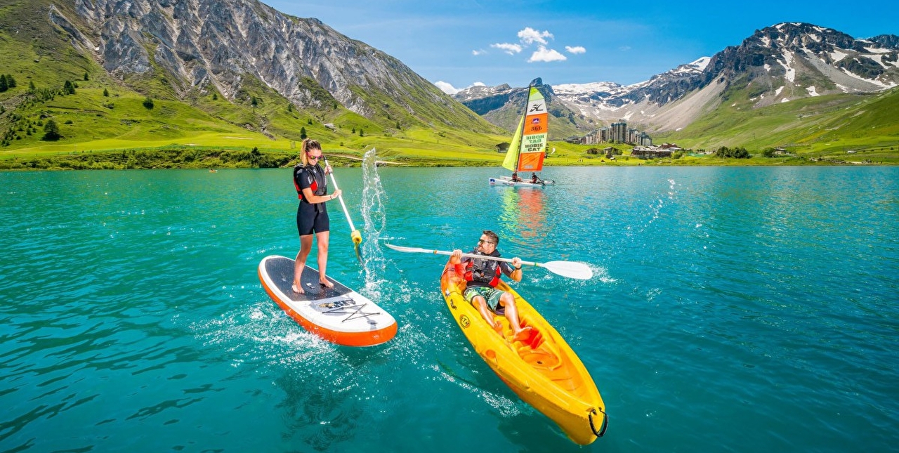 Session de stand-up paddle et de canoë-kayac sur le lac de Tignes en montagne l'été