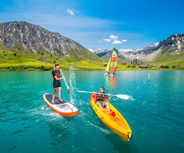 Session de stand-up paddle et de canoë-kayac sur le lac de Tignes en montagne l'été