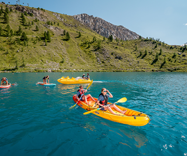 Famille en train de faire du kayak sur un lac de montagne en été