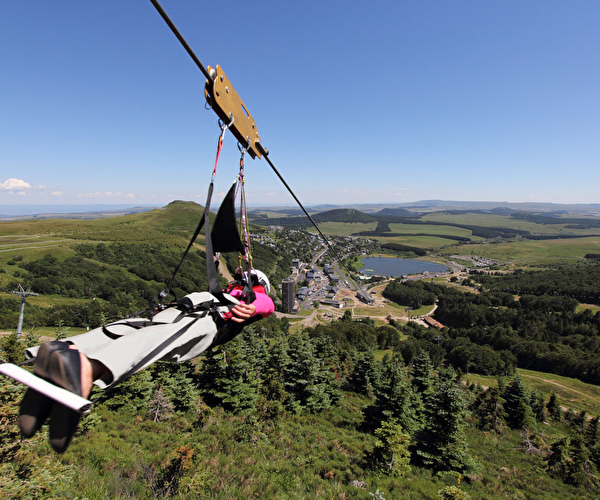 Femme effectuant une descente en tyrolienne en plaine nature
