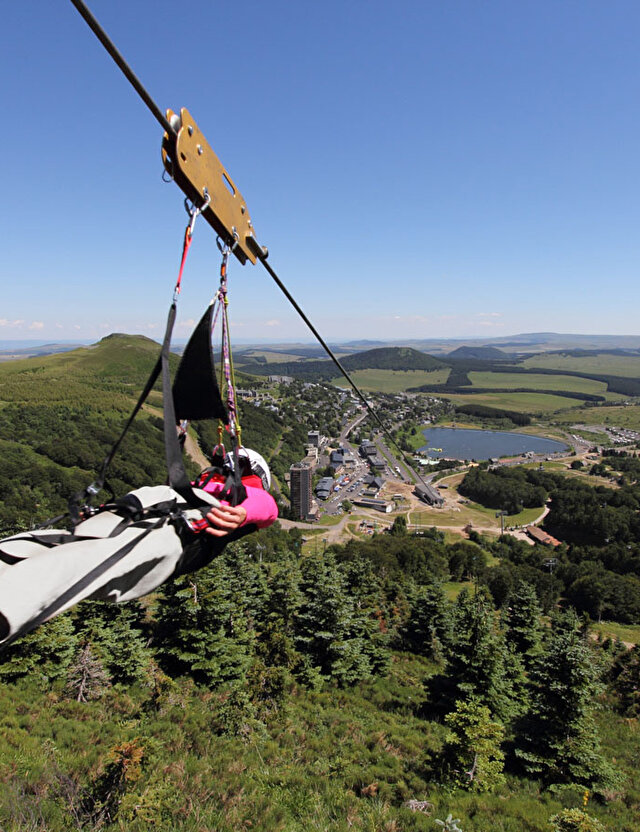 Femme effectuant une descente en tyrolienne en plaine nature