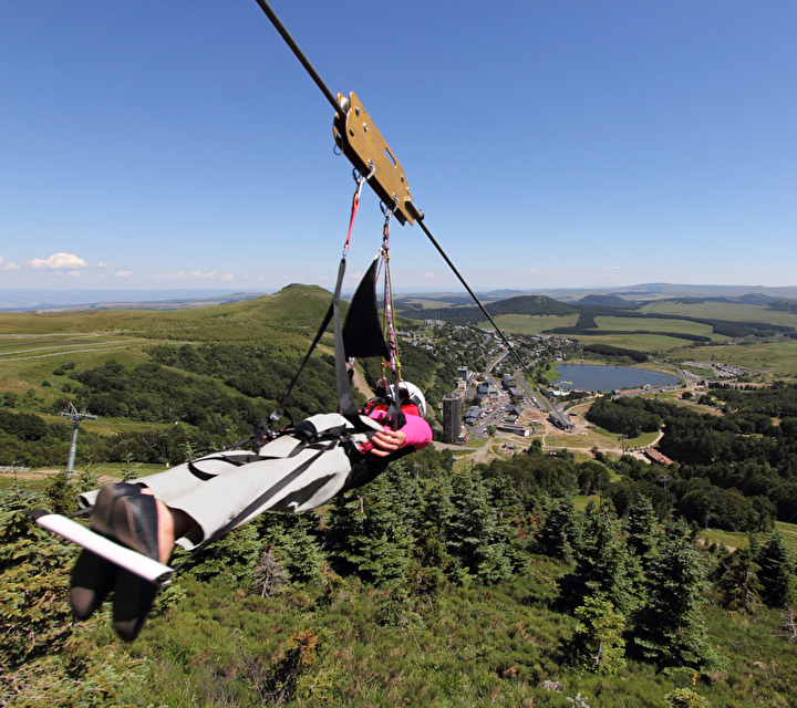 Femme effectuant une descente en tyrolienne en plaine nature