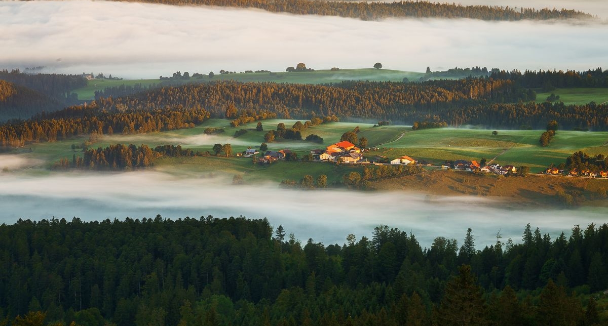 Vue panoramique sur la vallée et sa nature environnante sous une large bande de nuages blancs
