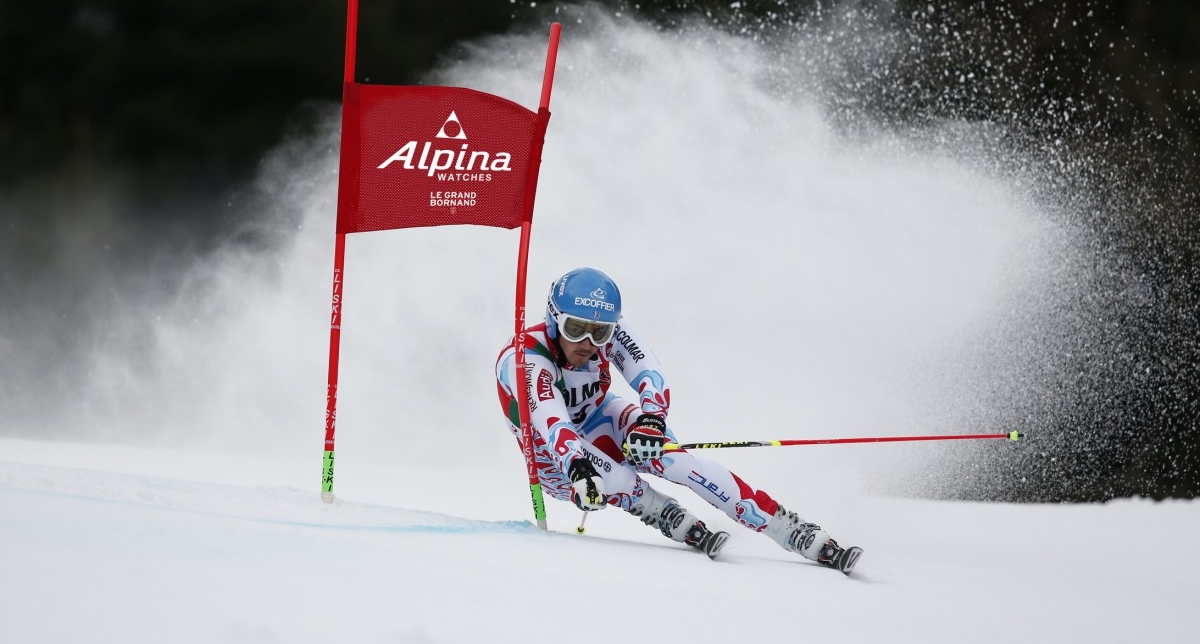 Personne effectuant une descente de slalom et franchissant une porte sur une piste de ski en montagne l'hiver