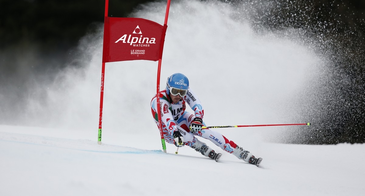 Personne effectuant une descente de slalom et franchissant une porte sur une piste de ski en montagne l'hiver