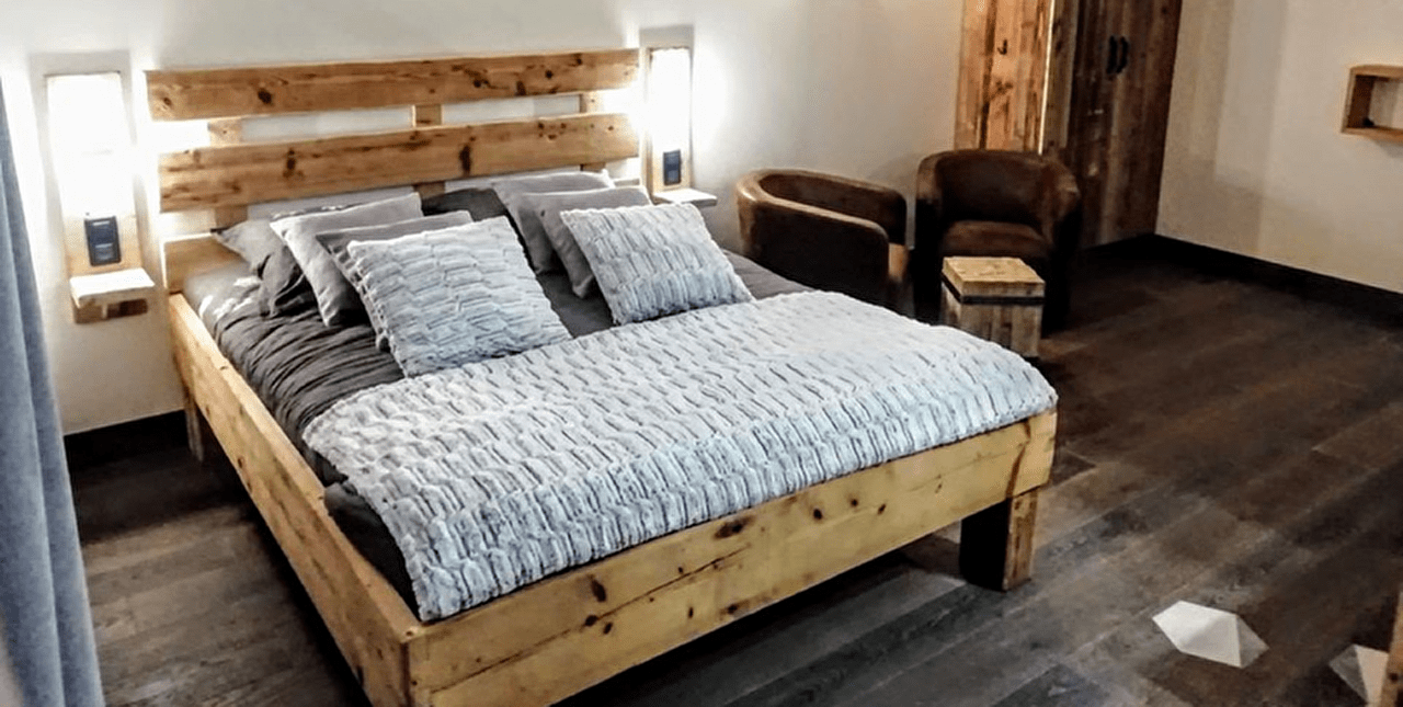 Intérieur d'une chambre avec lit double, fauteuils et table basse