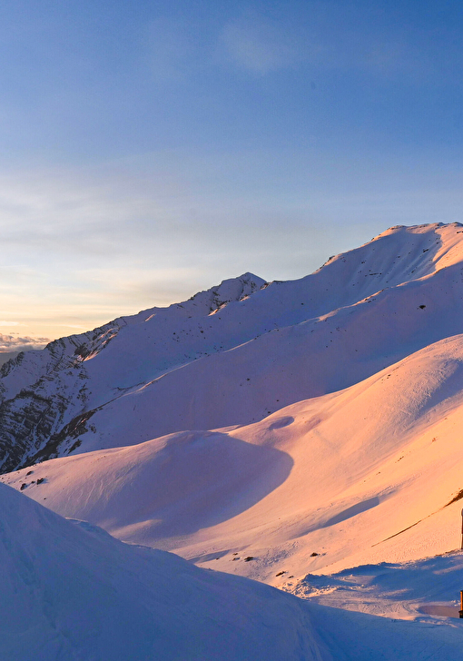 Coucher de soleil sur les sommets de montagne enneigés