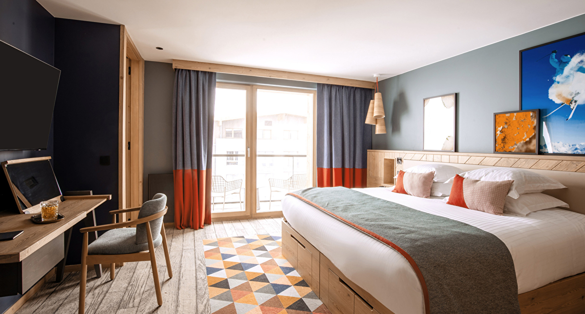 Chambre Club Med équipée d'un lit, d'un bureau et d'une télévision, idéale pour un séjour relaxant.