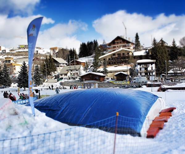 Big air bag positionné au sol dans une station à la montagne l'hiver